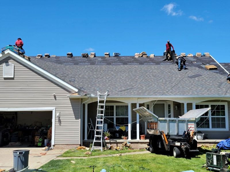Wheeler crew installing asphalt shingles on a residential roof